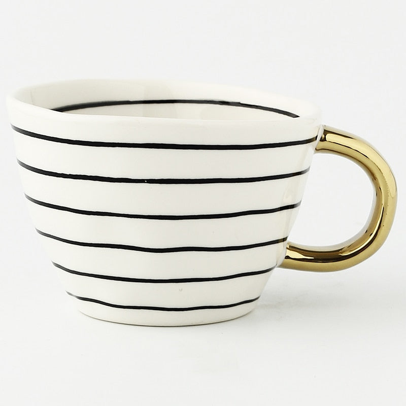 Cup with abstract geometric pattern and gold handle