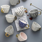 Cup with abstract geometric pattern and gold handle