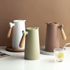 Elegant double-walled glass carafe with wooden handle for hot and cold drinks