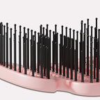 Curved hairbrush with ventilation